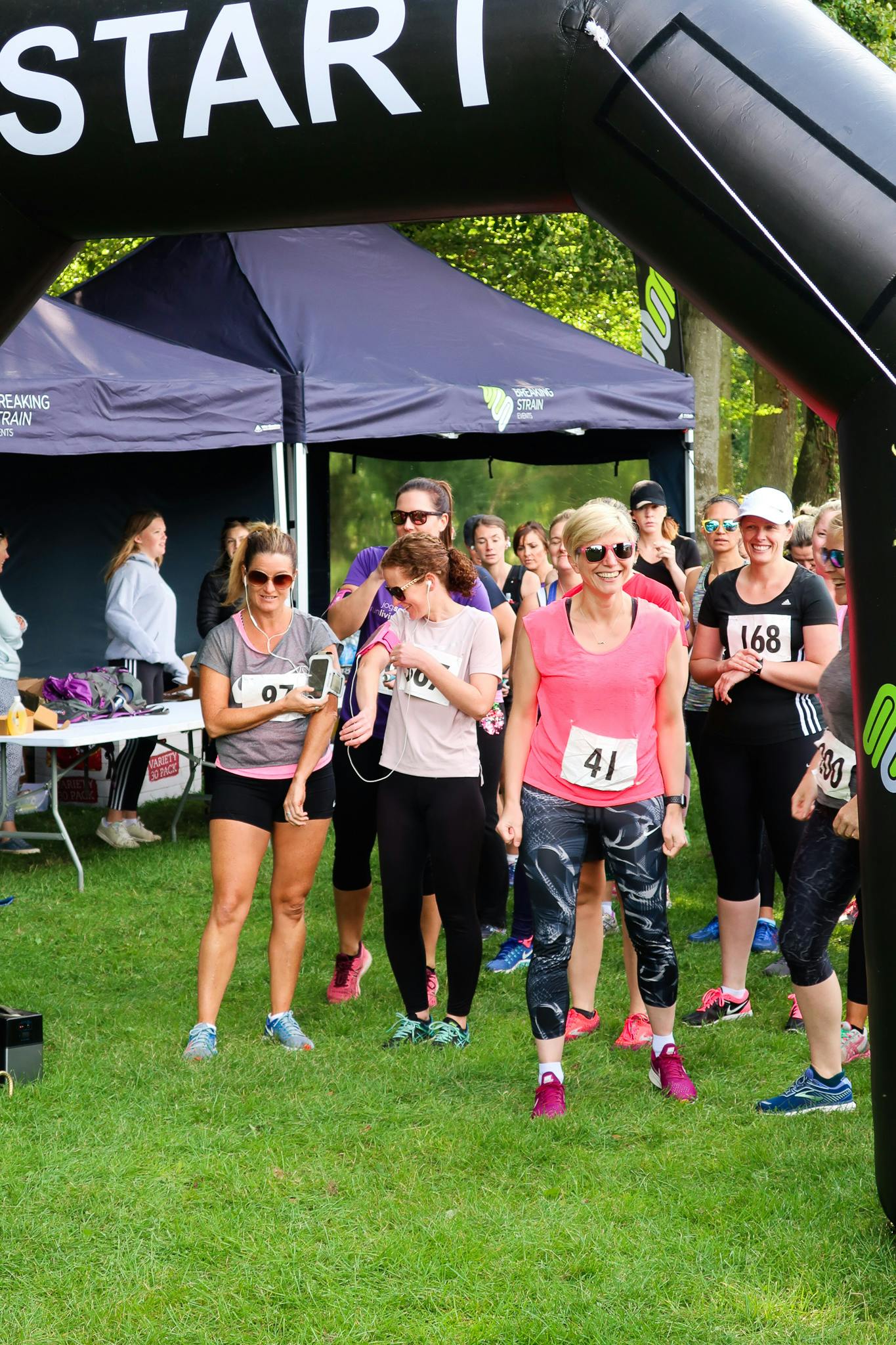 women at the start line smiling preparing to run the runnyegg 10k