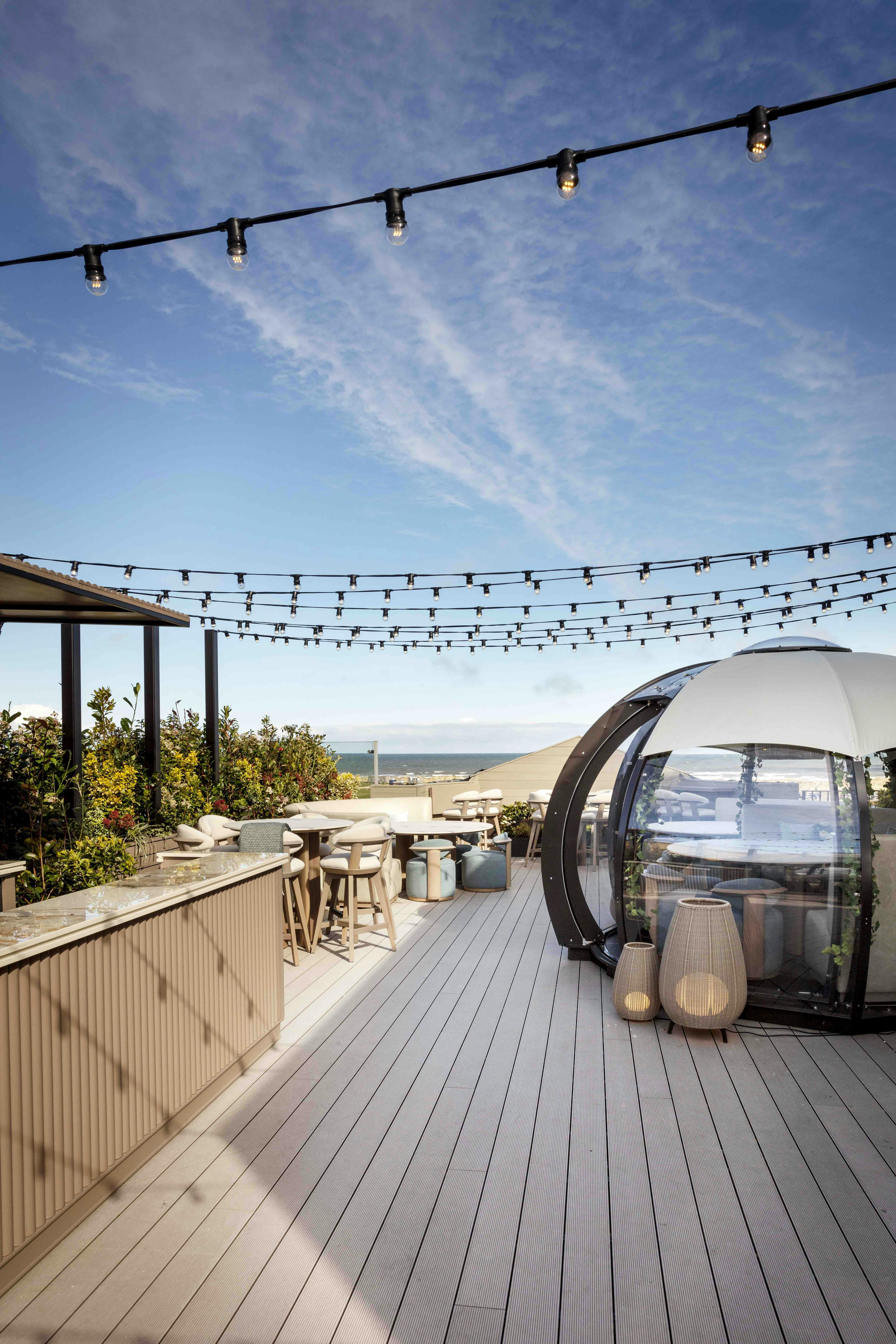 West Deck at The Old Course Hotel with cosy pods in summer sun, perfect for al fresco dining and cocktails