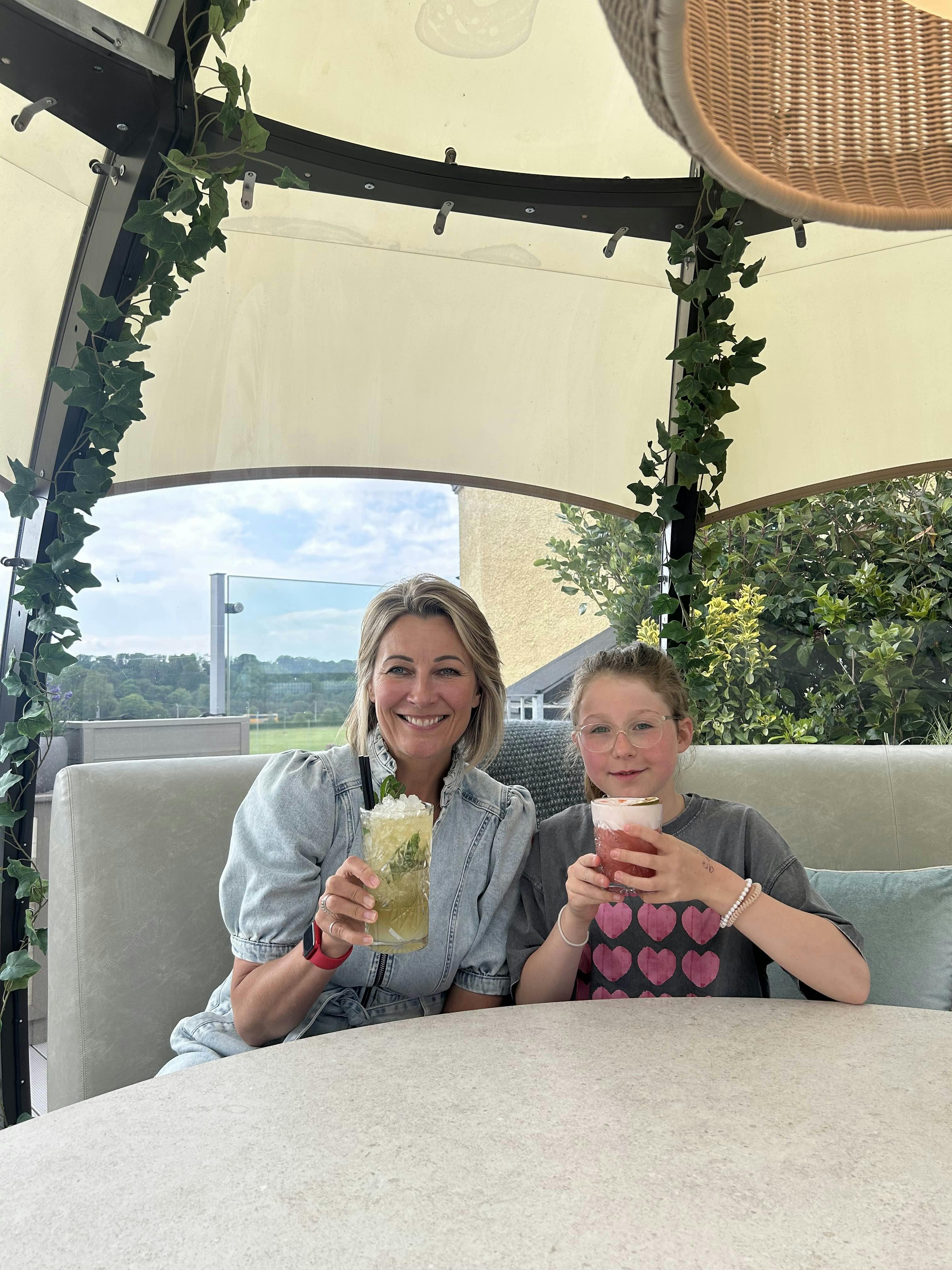 Kylie and Ottilie enjoying mocktails in a sunlit pod on the West Deck, The Old Course Hotel